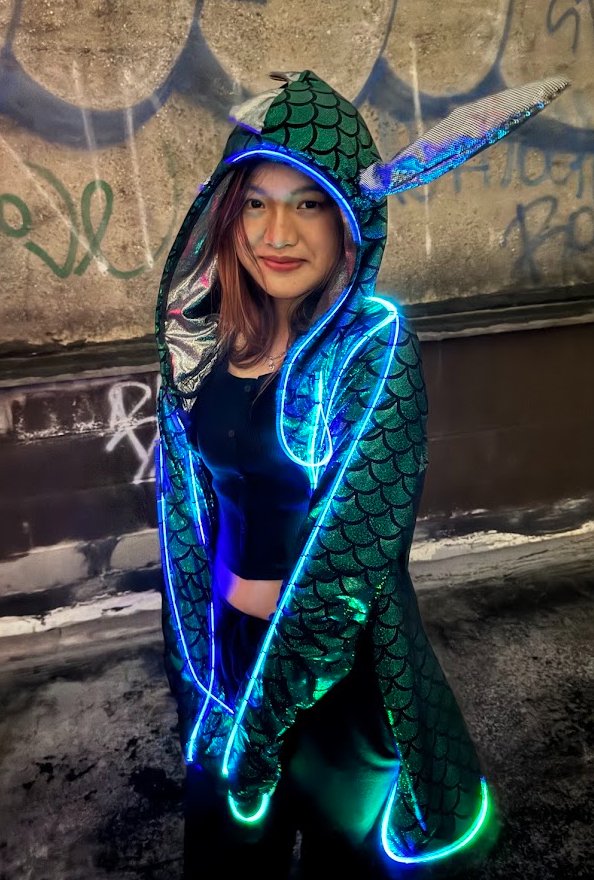 A hooded cloak traced in blue and green Trippy Wire.